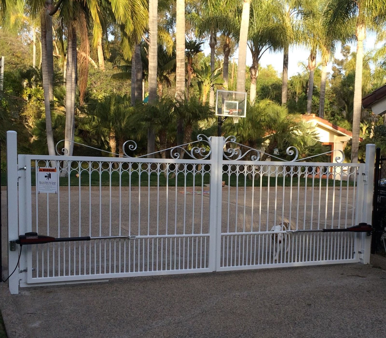 White ornamental metal double driveway gate with automatic gate operators